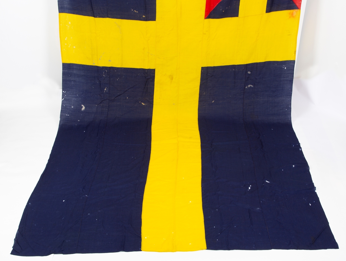Svensk flagg med unionsmerke, "sildesalaten". Metallhempe. Møllspist og slitt.
Unionsmerket: 120 x 103

Givers datter opplyser at flagget var kjøpt på auksjon eller loppemarked på 1980 tallet. Det skal ha kommet fra båtbyggeriet på Kugrava i Son.