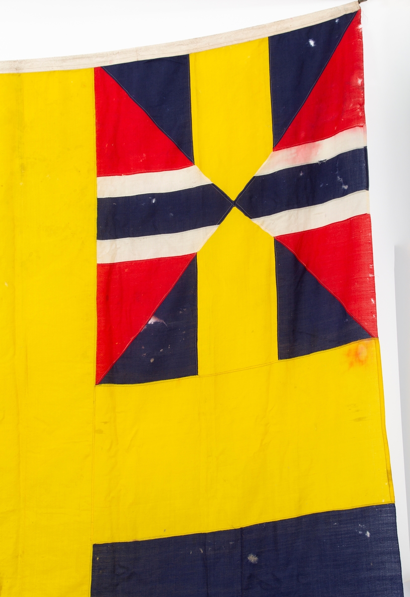 Svensk flagg med unionsmerke, "sildesalaten". Metallhempe. Møllspist og slitt.
Unionsmerket: 120 x 103

Givers datter opplyser at flagget var kjøpt på auksjon eller loppemarked på 1980 tallet. Det skal ha kommet fra båtbyggeriet på Kugrava i Son.