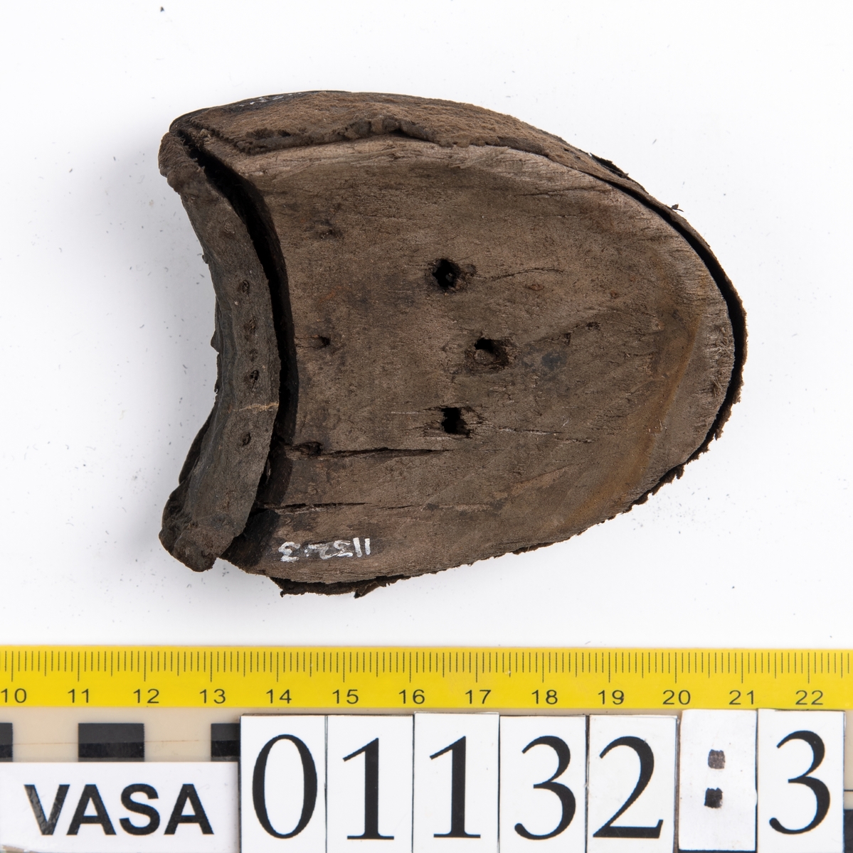 Fem delar av en recent sko.
Sula fyndnummer 01132 har hål efter skopligg och kvarsittande tråd. Sulan är mycket kraftig och välbevarad.
Del av sula, fyndnummer 01123:1, har hål efter skopligg och stygn runt om. Lädret är mycket kraftigt och välbevarat.
En bakkappa fyndnummer 01132:2. På narvsidans mitt samt i nedre kanten finns hål efter stygn. Lädret är mycket kraftigt och välbevarat.
En träklack fyndnummer 01132:3. Klackens kanter omsluts av ett tunt och spaltat lager av läder. Vid den klackkant som är vänd mot hålfoten sitter en kraftig, rektangulär läderbit fästad. På klackens undersida är förstärkt med en kraftig läderbit. Under denna sitter en laglapp. Klacken har kvarsittande träpligg.
En ospecificerad, rektangulär läderbit, fyndnummer 01123:4. Längs med ytterkanterna löper hål. Lädret är kraftigt, narvsidan är dock något spaltad.