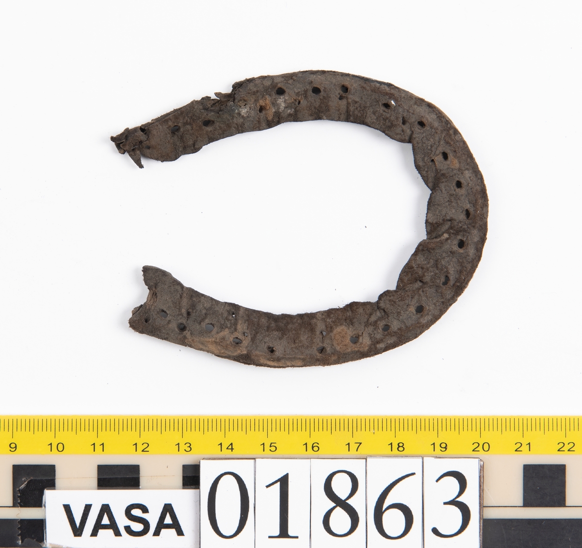 Fyra delar av en sko.
Ovanlädret, fyndnummer 01863, är kraftigt. Strax nedanför tungan finns två snörhål. På ena sidan av ovanlädret har en spricka täckts med en laglapp. Små stygnshål löper längs med kanten på sprickan. Rosettformad mindre öppning i tåpartiet. Ovanlädret är böjt och köttsidan är vänd utåt.
Stropp, fyndnummer 01863:1, har troligtvis varit fästad i skons bakparti eller i sidostycket.
Laglapp, fyndnummer 01863:2, har varit fästad på ovanlädret och täckt en spricka i lädret.
Holtrand, fyndnummer 01863:3, har omslutit delar av bottenlädret.