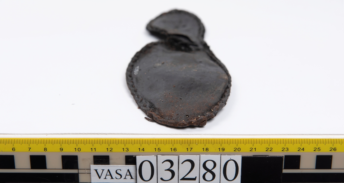 Tjugofem delar och fragment från stövel.
En sula, fyndnummer 03280. På sulans ovansida syns intryck av bindtråd. Runt ytterkanterna löper stygnshål. I hälpartiet finns hål efter träpligg.
Del av en klack, fyndnummer 03280:1, i form av fyra klacklappar samt kvarsittande träpligg.
En stropp, fyndnummer 03280:2. Ena änden är spetsformad. Andra änden är något fragmentarisk. I bägge ändar finns hål efter stygn.
Tre delar från stövelskaftet i form av tre läderstycken. Lädrstyckena är spaltade och ligger vikta. Längs sidorna löper stygnshål.
Delar och fragment av sulor, inlägg, ovanläder mm.
Merparten av lädret är spaltat och något kladdigt.