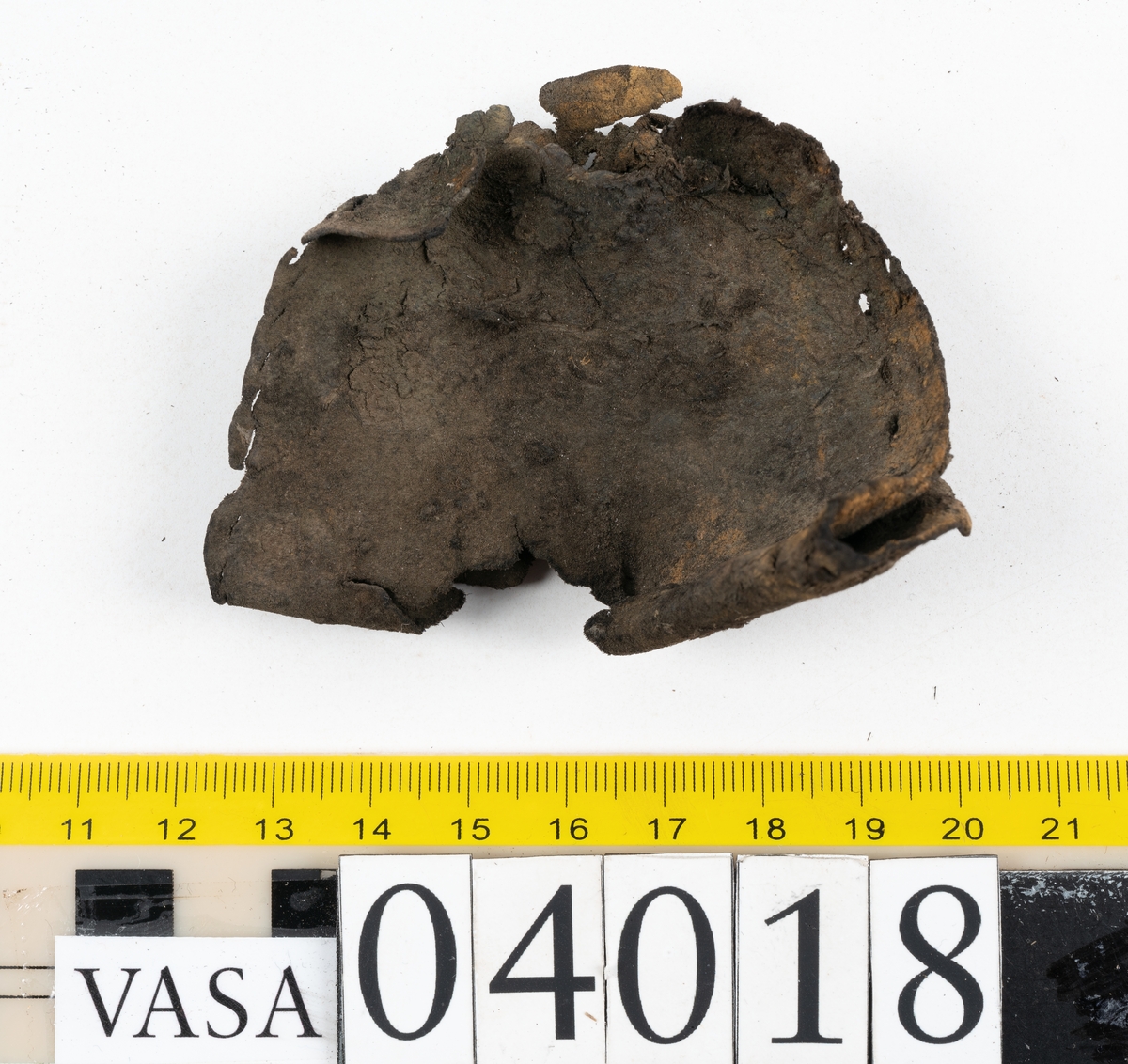 Tolv fragment av sko, varav två fragment kan vara delar från en slejf.
Lädret är mycket sprött och hårt.