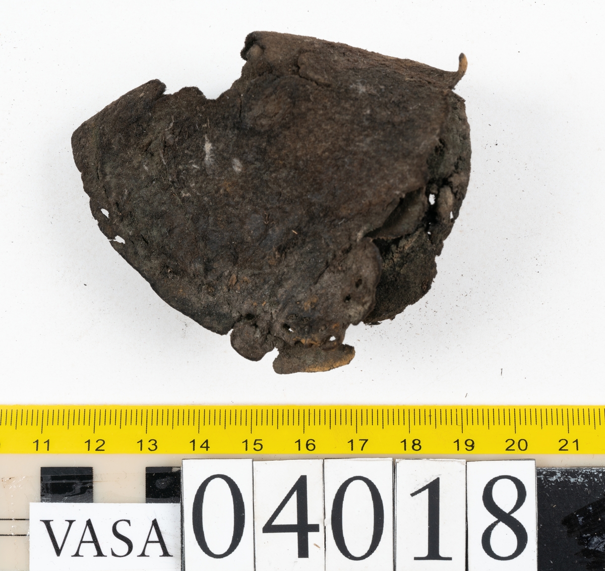 Tolv fragment av sko, varav två fragment kan vara delar från en slejf.
Lädret är mycket sprött och hårt.