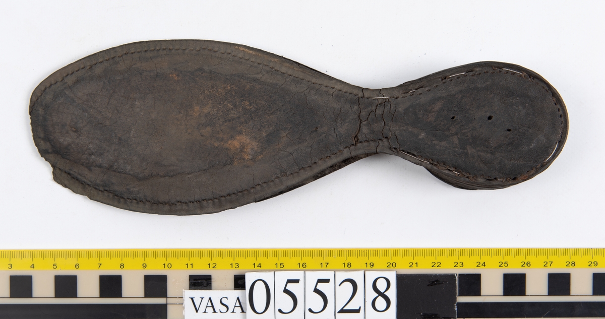 Dokumentation 1997:
Ett tjugotal delar och fragment från ett par skor.
Del av en skobotten, fyndnummer 05528. Skobottnen består av två sulor mellan vilka klacklappar sitter fästade. Sulorna och klacklapparna har monterats samman med tråd av konserveringsenheten.
En klack, fyndnummer 05528:1. Klacken är uppbyggd av sju klacklappar. Klacken har monterats samman med tråd av konserveringsenheten.
Två sulor, fyndnummer 05528:2 samt 05528:3. Sula fyndnummer 05528:3 har ett nedslitet hälparti. Sulorna och klacken är delar från den andra skobottnen som bildar par med skobotten fyndnummer 05528.
Två sulor, fyndnummer 05528:4 och 05528:5. Sulorna hör samman med någon av de två ovan nämnda skobottnarna.
Ett sidosycke med slejf, fyndnummer 05528:6. Längs med sidostyckets nedre kant löper stygnshål.
Ett 15-tal delar och fragment av holtrand, sulor mm.
Lädret är kraftigt och välbevarat.

Dokumentation 2022:
Fragment från ovanläder och ett par skobottnar (05528:4). Framstycke och sulor till öppna randskor. Tillverkade i läder. Skapades på en rak läst och bars på höger fot. Det finns regelbundna skurna dekorationer på framstycket. Klacken är reparerad med en läderlapp under sulan. Det finns tecken på delaminering på framstycket. Det finns hål i skobottens sidor och i mittensulan. Det finns inga tecken på lagningar.
För mer information, se Uppritning under Länkade filer.

Text in english:
These are one vamp fragment and a pair of bottom units (05528:4) of open side latchet shoes, made of leather, of randed construction with a patch heel, made on a straight last and worn on the right foot, with decorative pinked features across the vamp. The vamps are delaminated, and the bottom unit presents holes on both lateral sides and on the midsole. There are no signs of repairs.
For more information, go to Länkade filer: Uppritning