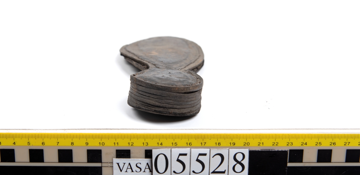 Dokumentation 1997:
Ett tjugotal delar och fragment från ett par skor.
Del av en skobotten, fyndnummer 05528. Skobottnen består av två sulor mellan vilka klacklappar sitter fästade. Sulorna och klacklapparna har monterats samman med tråd av konserveringsenheten.
En klack, fyndnummer 05528:1. Klacken är uppbyggd av sju klacklappar. Klacken har monterats samman med tråd av konserveringsenheten.
Två sulor, fyndnummer 05528:2 samt 05528:3. Sula fyndnummer 05528:3 har ett nedslitet hälparti. Sulorna och klacken är delar från den andra skobottnen som bildar par med skobotten fyndnummer 05528.
Två sulor, fyndnummer 05528:4 och 05528:5. Sulorna hör samman med någon av de två ovan nämnda skobottnarna.
Ett sidosycke med slejf, fyndnummer 05528:6. Längs med sidostyckets nedre kant löper stygnshål.
Ett 15-tal delar och fragment av holtrand, sulor mm.
Lädret är kraftigt och välbevarat.

Dokumentation 2022:
Fragment från ovanläder och ett par skobottnar (05528:4). Framstycke och sulor till öppna randskor. Tillverkade i läder. Skapades på en rak läst och bars på höger fot. Det finns regelbundna skurna dekorationer på framstycket. Klacken är reparerad med en läderlapp under sulan. Det finns tecken på delaminering på framstycket. Det finns hål i skobottens sidor och i mittensulan. Det finns inga tecken på lagningar.
För mer information, se Uppritning under Länkade filer.

Text in english:
These are one vamp fragment and a pair of bottom units (05528:4) of open side latchet shoes, made of leather, of randed construction with a patch heel, made on a straight last and worn on the right foot, with decorative pinked features across the vamp. The vamps are delaminated, and the bottom unit presents holes on both lateral sides and on the midsole. There are no signs of repairs.
For more information, go to Länkade filer: Uppritning