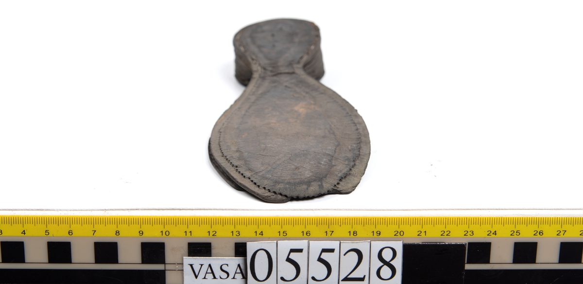 Dokumentation 1997:
Ett tjugotal delar och fragment från ett par skor.
Del av en skobotten, fyndnummer 05528. Skobottnen består av två sulor mellan vilka klacklappar sitter fästade. Sulorna och klacklapparna har monterats samman med tråd av konserveringsenheten.
En klack, fyndnummer 05528:1. Klacken är uppbyggd av sju klacklappar. Klacken har monterats samman med tråd av konserveringsenheten.
Två sulor, fyndnummer 05528:2 samt 05528:3. Sula fyndnummer 05528:3 har ett nedslitet hälparti. Sulorna och klacken är delar från den andra skobottnen som bildar par med skobotten fyndnummer 05528.
Två sulor, fyndnummer 05528:4 och 05528:5. Sulorna hör samman med någon av de två ovan nämnda skobottnarna.
Ett sidosycke med slejf, fyndnummer 05528:6. Längs med sidostyckets nedre kant löper stygnshål.
Ett 15-tal delar och fragment av holtrand, sulor mm.
Lädret är kraftigt och välbevarat.

Dokumentation 2022:
Fragment från ovanläder och ett par skobottnar (05528:4). Framstycke och sulor till öppna randskor. Tillverkade i läder. Skapades på en rak läst och bars på höger fot. Det finns regelbundna skurna dekorationer på framstycket. Klacken är reparerad med en läderlapp under sulan. Det finns tecken på delaminering på framstycket. Det finns hål i skobottens sidor och i mittensulan. Det finns inga tecken på lagningar.
För mer information, se Uppritning under Länkade filer.

Text in english:
These are one vamp fragment and a pair of bottom units (05528:4) of open side latchet shoes, made of leather, of randed construction with a patch heel, made on a straight last and worn on the right foot, with decorative pinked features across the vamp. The vamps are delaminated, and the bottom unit presents holes on both lateral sides and on the midsole. There are no signs of repairs.
For more information, go to Länkade filer: Uppritning
