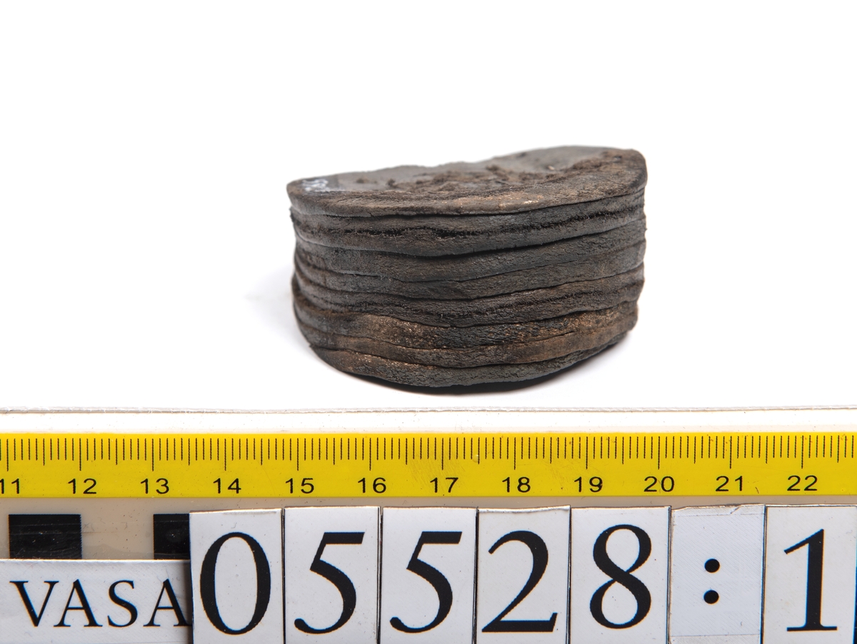 Dokumentation 1997:
Ett tjugotal delar och fragment från ett par skor.
Del av en skobotten, fyndnummer 05528. Skobottnen består av två sulor mellan vilka klacklappar sitter fästade. Sulorna och klacklapparna har monterats samman med tråd av konserveringsenheten.
En klack, fyndnummer 05528:1. Klacken är uppbyggd av sju klacklappar. Klacken har monterats samman med tråd av konserveringsenheten.
Två sulor, fyndnummer 05528:2 samt 05528:3. Sula fyndnummer 05528:3 har ett nedslitet hälparti. Sulorna och klacken är delar från den andra skobottnen som bildar par med skobotten fyndnummer 05528.
Två sulor, fyndnummer 05528:4 och 05528:5. Sulorna hör samman med någon av de två ovan nämnda skobottnarna.
Ett sidosycke med slejf, fyndnummer 05528:6. Längs med sidostyckets nedre kant löper stygnshål.
Ett 15-tal delar och fragment av holtrand, sulor mm.
Lädret är kraftigt och välbevarat.

Dokumentation 2022:
Fragment från ovanläder och ett par skobottnar (05528:4). Framstycke och sulor till öppna randskor. Tillverkade i läder. Skapades på en rak läst och bars på höger fot. Det finns regelbundna skurna dekorationer på framstycket. Klacken är reparerad med en läderlapp under sulan. Det finns tecken på delaminering på framstycket. Det finns hål i skobottens sidor och i mittensulan. Det finns inga tecken på lagningar.
För mer information, se Uppritning under Länkade filer.

Text in english:
These are one vamp fragment and a pair of bottom units (05528:4) of open side latchet shoes, made of leather, of randed construction with a patch heel, made on a straight last and worn on the right foot, with decorative pinked features across the vamp. The vamps are delaminated, and the bottom unit presents holes on both lateral sides and on the midsole. There are no signs of repairs.
For more information, go to Länkade filer: Uppritning