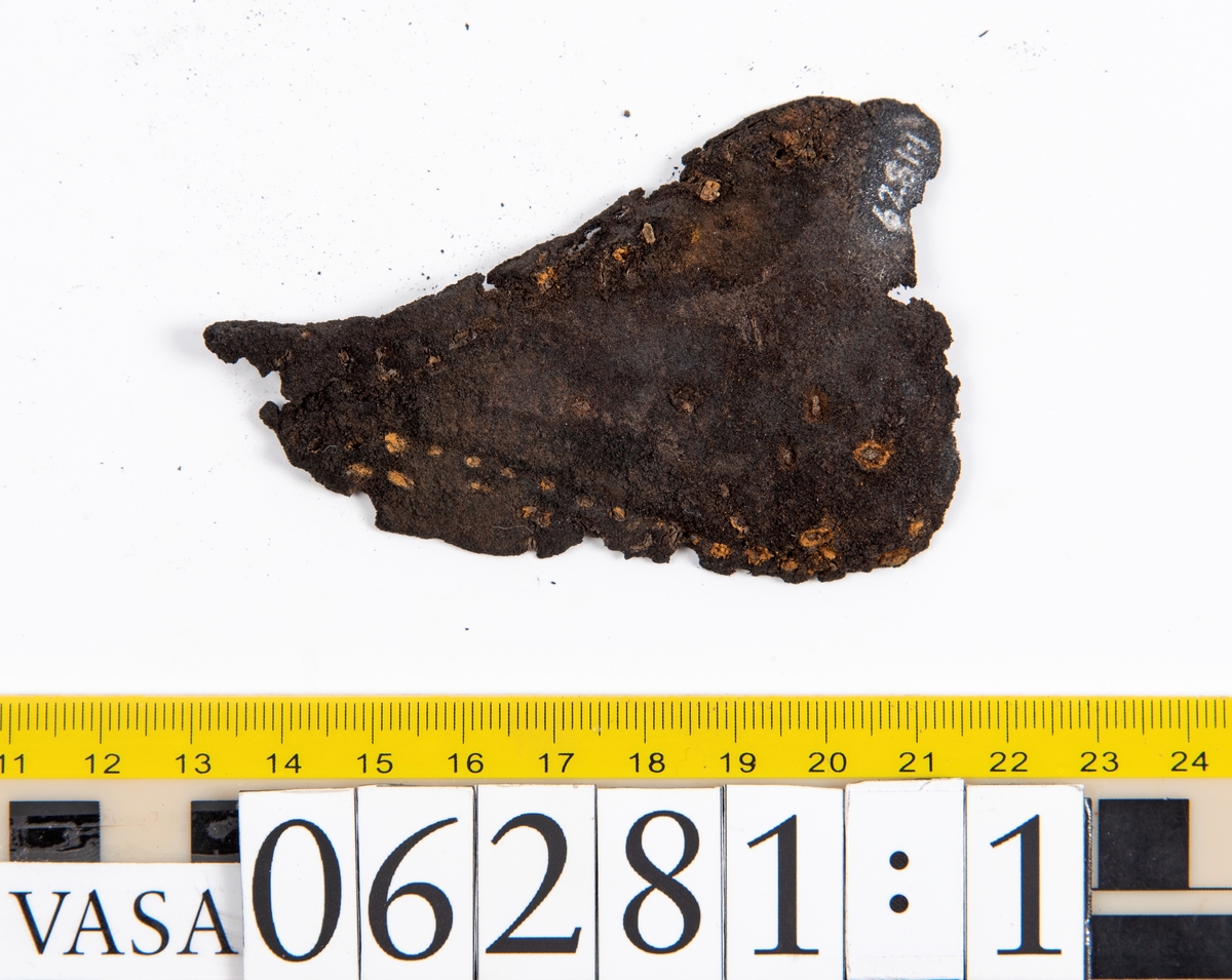 Delar och fragment av skobotten: klacklapp, del av sula samt tretton mindre fragment.

Klacklappen fyndnummer 06281, har hål efter två träpligg. Lädret är kraftigt. Del av sula med kvarsittande träpligg, fyndnummer 06281:1. Längs med sulans ytterkant löper dubbla rader av stygnshål. De fem fragmenten härrör troligtvis från sulor.

Lädret är rostfärgat och mycket sprött.