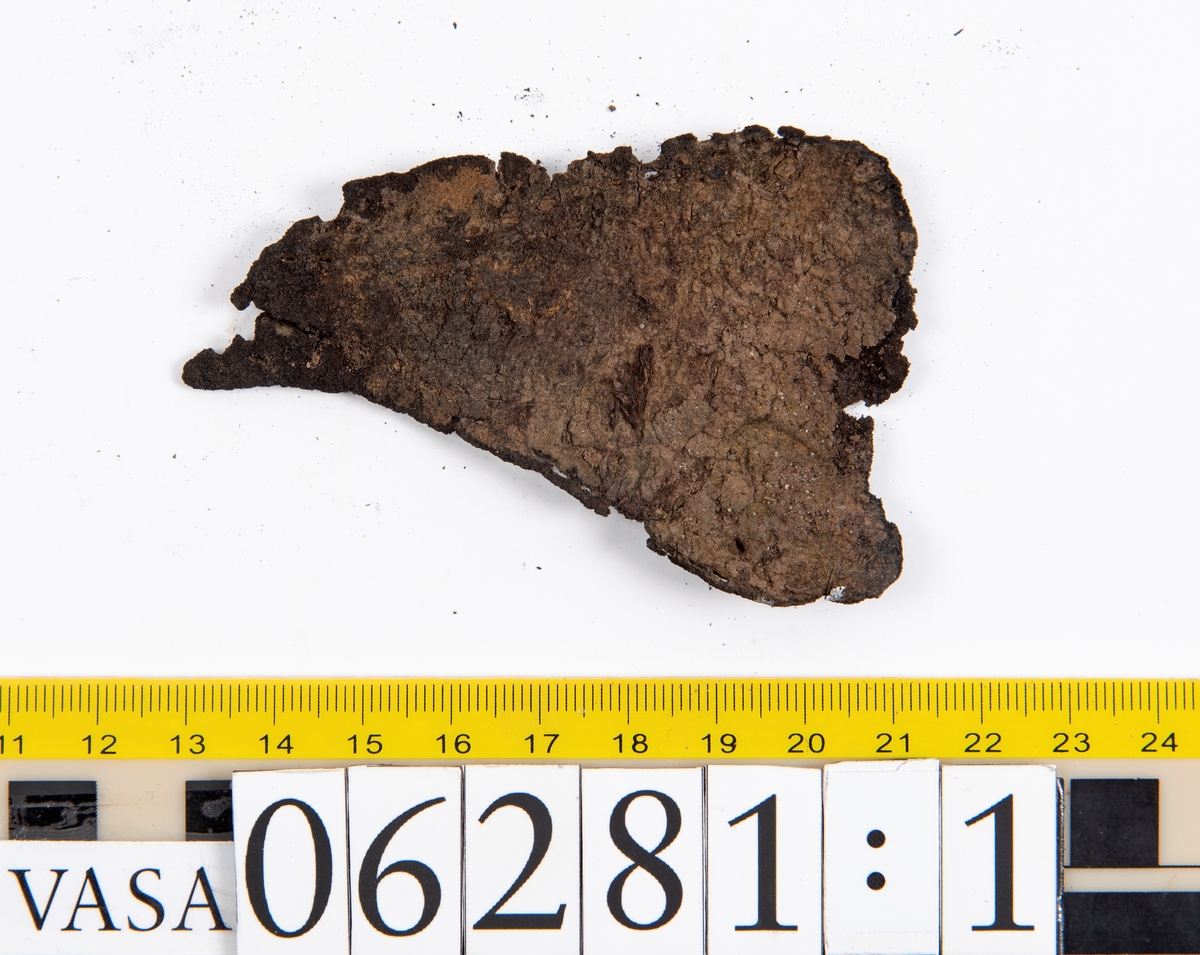 Delar och fragment av skobotten: klacklapp, del av sula samt tretton mindre fragment.

Klacklappen fyndnummer 06281, har hål efter två träpligg. Lädret är kraftigt. Del av sula med kvarsittande träpligg, fyndnummer 06281:1. Längs med sulans ytterkant löper dubbla rader av stygnshål. De fem fragmenten härrör troligtvis från sulor.

Lädret är rostfärgat och mycket sprött.