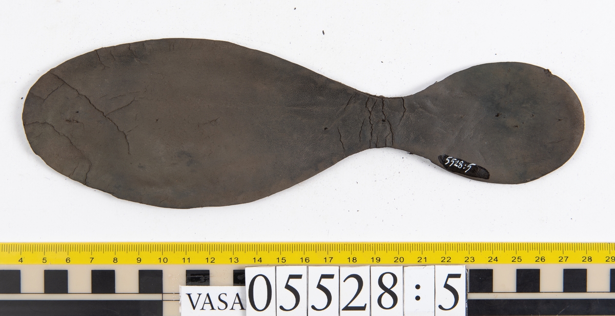 Dokumentation 1997:
Ett tjugotal delar och fragment från ett par skor.
Del av en skobotten, fyndnummer 05528. Skobottnen består av två sulor mellan vilka klacklappar sitter fästade. Sulorna och klacklapparna har monterats samman med tråd av konserveringsenheten.
En klack, fyndnummer 05528:1. Klacken är uppbyggd av sju klacklappar. Klacken har monterats samman med tråd av konserveringsenheten.
Två sulor, fyndnummer 05528:2 samt 05528:3. Sula fyndnummer 05528:3 har ett nedslitet hälparti. Sulorna och klacken är delar från den andra skobottnen som bildar par med skobotten fyndnummer 05528.
Två sulor, fyndnummer 05528:4 och 05528:5. Sulorna hör samman med någon av de två ovan nämnda skobottnarna.
Ett sidosycke med slejf, fyndnummer 05528:6. Längs med sidostyckets nedre kant löper stygnshål.
Ett 15-tal delar och fragment av holtrand, sulor mm.
Lädret är kraftigt och välbevarat.

Dokumentation 2022:
Fragment från ovanläder och ett par skobottnar (05528:4). Framstycke och sulor till öppna randskor. Tillverkade i läder. Skapades på en rak läst och bars på höger fot. Det finns regelbundna skurna dekorationer på framstycket. Klacken är reparerad med en läderlapp under sulan. Det finns tecken på delaminering på framstycket. Det finns hål i skobottens sidor och i mittensulan. Det finns inga tecken på lagningar.
För mer information, se Uppritning under Länkade filer.

Text in english:
These are one vamp fragment and a pair of bottom units (05528:4) of open side latchet shoes, made of leather, of randed construction with a patch heel, made on a straight last and worn on the right foot, with decorative pinked features across the vamp. The vamps are delaminated, and the bottom unit presents holes on both lateral sides and on the midsole. There are no signs of repairs.
For more information, go to Länkade filer: Uppritning