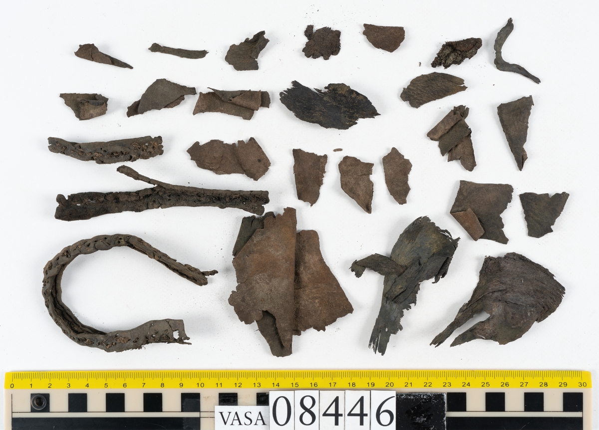 Delar och fragment från skobotten: fem delar samt ett åttiotal fragment.

Skobotten 08446 har kvarsittande tråd och skopligg. Klacken består av tre klacklappar. Sula 08446:1 har ett något fragmentariskt hälparti. Del av bindsula, fyndnummer 08446:2. På sulan finns avtryck efter bindtråden och hål efter skopligg. Två delar av holtrand med kvarsittande tråd samt ett tiotal fragment och löst liggande skopligg.
