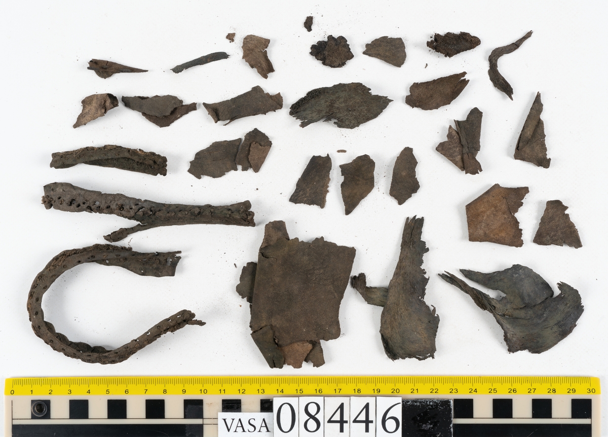 Delar och fragment från skobotten: fem delar samt ett åttiotal fragment.

Skobotten 08446 har kvarsittande tråd och skopligg. Klacken består av tre klacklappar. Sula 08446:1 har ett något fragmentariskt hälparti. Del av bindsula, fyndnummer 08446:2. På sulan finns avtryck efter bindtråden och hål efter skopligg. Två delar av holtrand med kvarsittande tråd samt ett tiotal fragment och löst liggande skopligg.