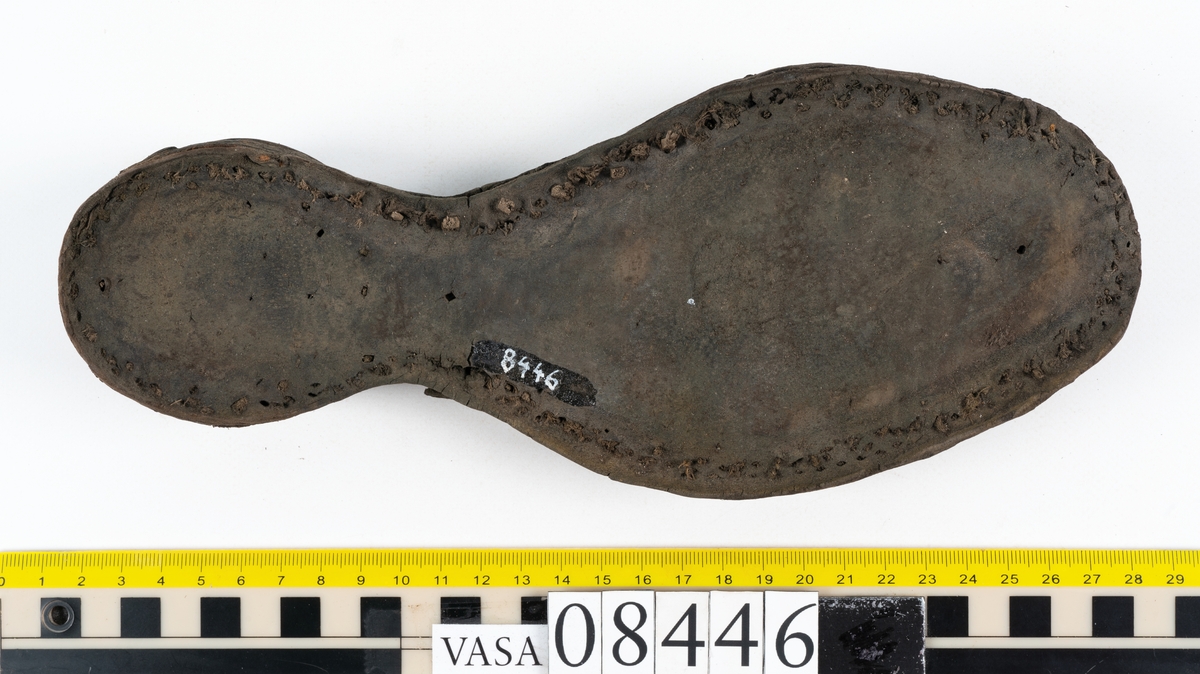 Delar och fragment från skobotten: fem delar samt ett åttiotal fragment.

Skobotten 08446 har kvarsittande tråd och skopligg. Klacken består av tre klacklappar. Sula 08446:1 har ett något fragmentariskt hälparti. Del av bindsula, fyndnummer 08446:2. På sulan finns avtryck efter bindtråden och hål efter skopligg. Två delar av holtrand med kvarsittande tråd samt ett tiotal fragment och löst liggande skopligg.