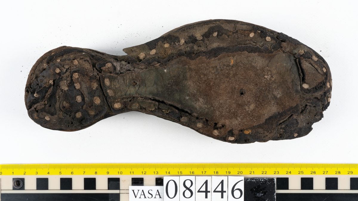Delar och fragment från skobotten: fem delar samt ett åttiotal fragment.

Skobotten 08446 har kvarsittande tråd och skopligg. Klacken består av tre klacklappar. Sula 08446:1 har ett något fragmentariskt hälparti. Del av bindsula, fyndnummer 08446:2. På sulan finns avtryck efter bindtråden och hål efter skopligg. Två delar av holtrand med kvarsittande tråd samt ett tiotal fragment och löst liggande skopligg.