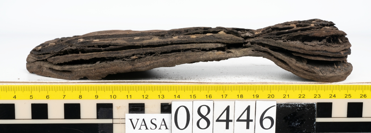 Delar och fragment från skobotten: fem delar samt ett åttiotal fragment.

Skobotten 08446 har kvarsittande tråd och skopligg. Klacken består av tre klacklappar. Sula 08446:1 har ett något fragmentariskt hälparti. Del av bindsula, fyndnummer 08446:2. På sulan finns avtryck efter bindtråden och hål efter skopligg. Två delar av holtrand med kvarsittande tråd samt ett tiotal fragment och löst liggande skopligg.