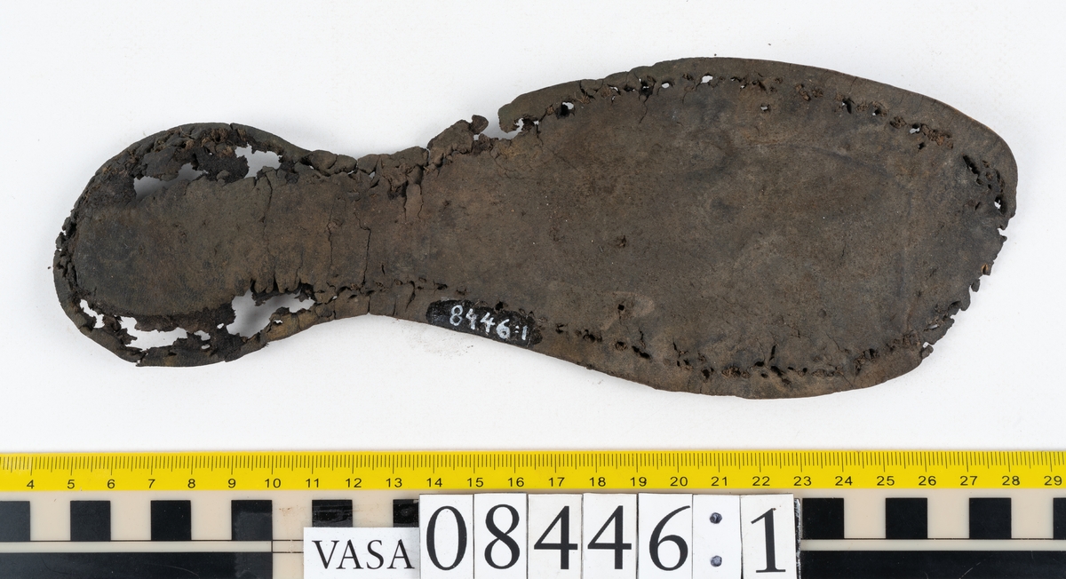 Delar och fragment från skobotten: fem delar samt ett åttiotal fragment.

Skobotten 08446 har kvarsittande tråd och skopligg. Klacken består av tre klacklappar. Sula 08446:1 har ett något fragmentariskt hälparti. Del av bindsula, fyndnummer 08446:2. På sulan finns avtryck efter bindtråden och hål efter skopligg. Två delar av holtrand med kvarsittande tråd samt ett tiotal fragment och löst liggande skopligg.
