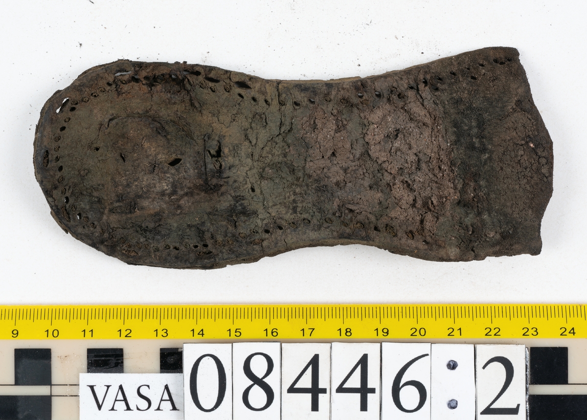 Delar och fragment från skobotten: fem delar samt ett åttiotal fragment.

Skobotten 08446 har kvarsittande tråd och skopligg. Klacken består av tre klacklappar. Sula 08446:1 har ett något fragmentariskt hälparti. Del av bindsula, fyndnummer 08446:2. På sulan finns avtryck efter bindtråden och hål efter skopligg. Två delar av holtrand med kvarsittande tråd samt ett tiotal fragment och löst liggande skopligg.