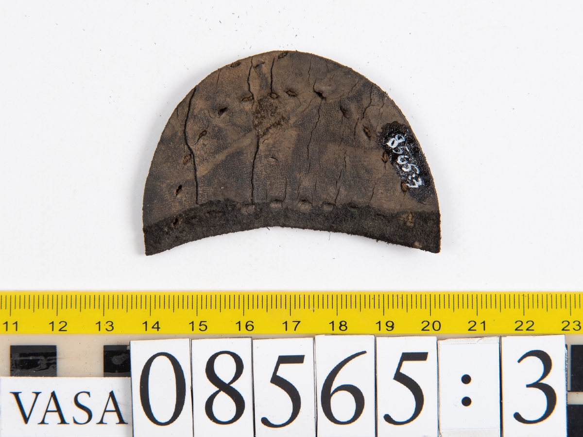Delar och fragment från skobottnar.
Sulor fyndnummer 08566, 08565:1 och 08565:2 härrör från en och samma skobotten. Sulorna har ett något spetsigt format tåparti.
Sula fyndnummer 08565:1 är avskuren vid partiet för hålfoten. I  den skurna kanten löper hål efter stygn. På sulans främre del finns hål efter träpligg.
Sula fyndnummer 08565:2 har ett fragmentariskt hälparti. På undersidan syns hål efter stygn med kvarsittande tråd.
En klacklapp, fyndnummer 08565:3.  Runt ytterkanterna löper hål efter träpligg eller stygn.
Ett inlägg från skobottens tåparti, fyndnummer 08565:4.
Totalt ett 45-tal fragment och delar av holtrand, sulor, inlägg m.m. samt ett filtfragment i två delar.