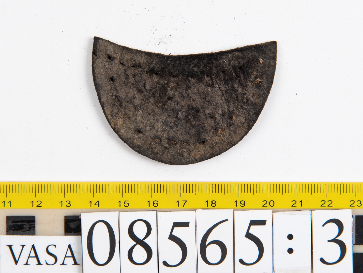 Delar och fragment från skobottnar.
Sulor fyndnummer 08566, 08565:1 och 08565:2 härrör från en och samma skobotten. Sulorna har ett något spetsigt format tåparti.
Sula fyndnummer 08565:1 är avskuren vid partiet för hålfoten. I  den skurna kanten löper hål efter stygn. På sulans främre del finns hål efter träpligg.
Sula fyndnummer 08565:2 har ett fragmentariskt hälparti. På undersidan syns hål efter stygn med kvarsittande tråd.
En klacklapp, fyndnummer 08565:3.  Runt ytterkanterna löper hål efter träpligg eller stygn.
Ett inlägg från skobottens tåparti, fyndnummer 08565:4.
Totalt ett 45-tal fragment och delar av holtrand, sulor, inlägg m.m. samt ett filtfragment i två delar.