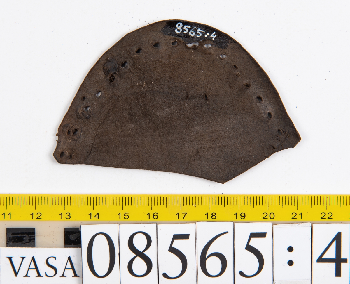 Delar och fragment från skobottnar.
Sulor fyndnummer 08566, 08565:1 och 08565:2 härrör från en och samma skobotten. Sulorna har ett något spetsigt format tåparti.
Sula fyndnummer 08565:1 är avskuren vid partiet för hålfoten. I  den skurna kanten löper hål efter stygn. På sulans främre del finns hål efter träpligg.
Sula fyndnummer 08565:2 har ett fragmentariskt hälparti. På undersidan syns hål efter stygn med kvarsittande tråd.
En klacklapp, fyndnummer 08565:3.  Runt ytterkanterna löper hål efter träpligg eller stygn.
Ett inlägg från skobottens tåparti, fyndnummer 08565:4.
Totalt ett 45-tal fragment och delar av holtrand, sulor, inlägg m.m. samt ett filtfragment i två delar.