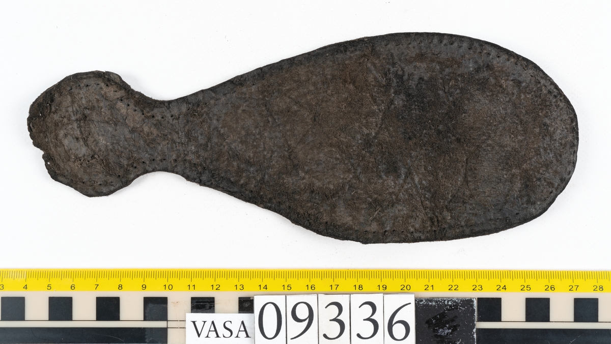 Fyra delar från sko: en sula, ett sidostycke med slejf samt två ospecificerade fragment.

En ritsad linje löper strax innanför sulans ytterkant. På sulans köttsida finns kvarsittande tråd. I änden på sidostyckets slejf syns ett runt hål med en nedskärning. På sidostycket syns kvarsittande tråd. Lädret är kraftigt.