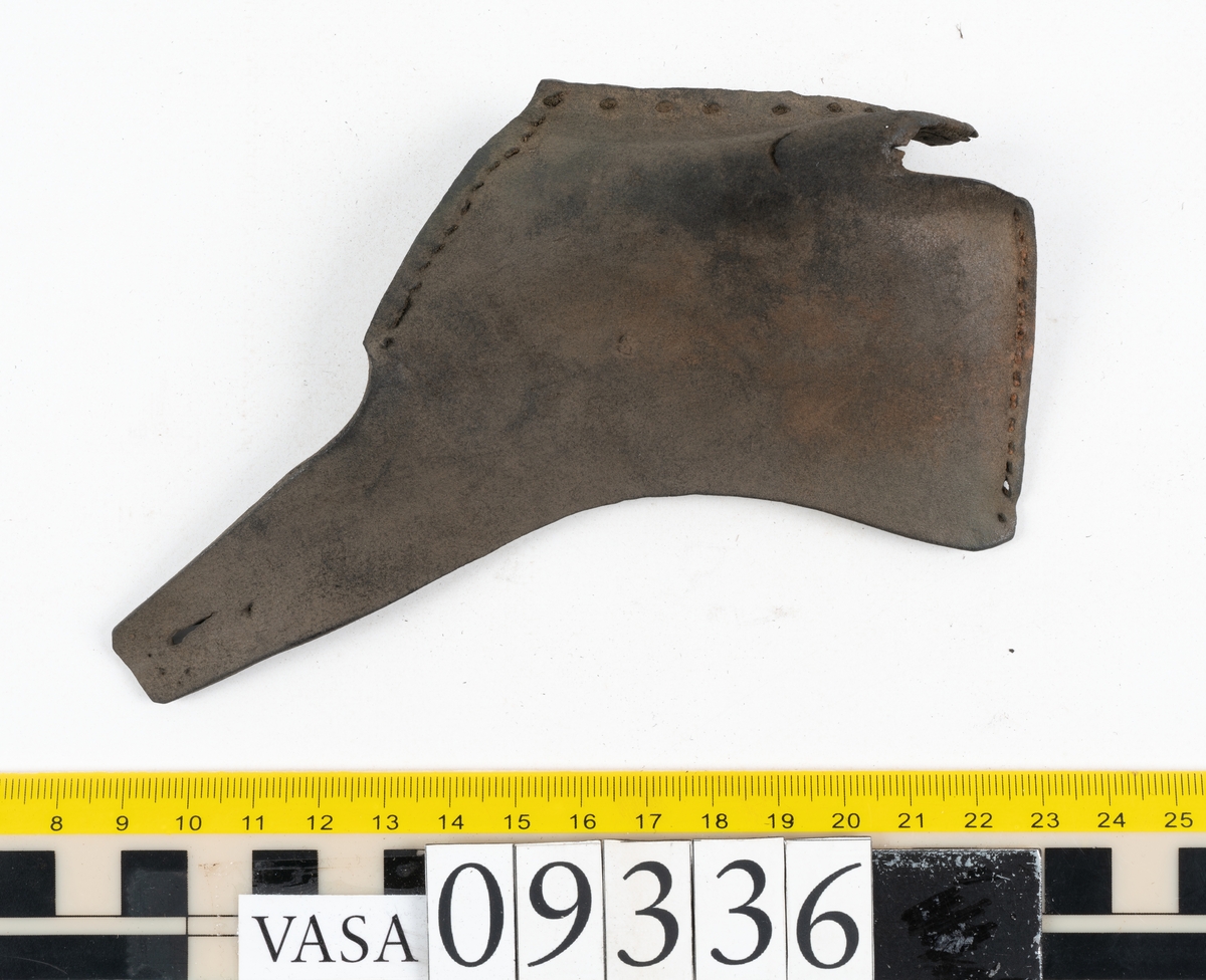 Fyra delar från sko: en sula, ett sidostycke med slejf samt två ospecificerade fragment.

En ritsad linje löper strax innanför sulans ytterkant. På sulans köttsida finns kvarsittande tråd. I änden på sidostyckets slejf syns ett runt hål med en nedskärning. På sidostycket syns kvarsittande tråd. Lädret är kraftigt.