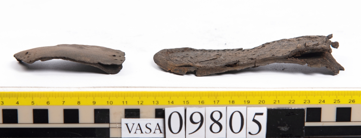 Ett 60-tal delar och fragment från sko: sulor, sidostycke, delar från klack m.m. samt ett filtfragment. Bland delarna kan urskiljas en klacklapp med kvarsittande skopligg samt ett sidostycke med slejf. I slejfänden finns ett hål - troligtvis knapphål.

Delar av lädret är kraftigt och välbevarat medan andra delar är spaltade samt har rostliknande utfällningar.
