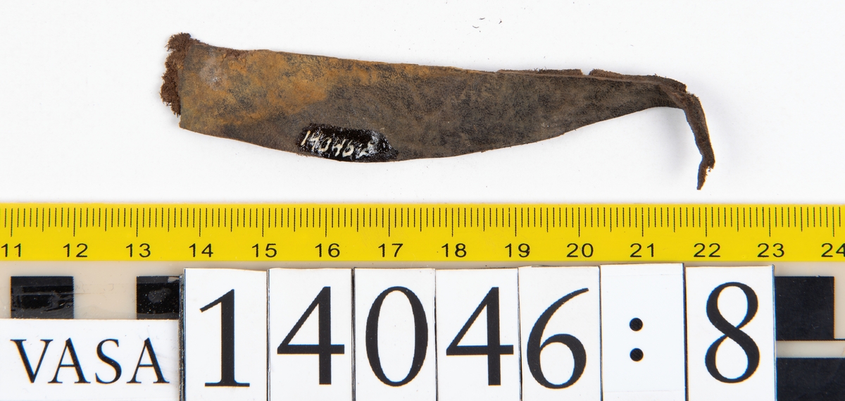 Tjugo ospecificerade läderbitar samt ett flertal mycket små fragment. På två av fragmenten, fyndnummer 14046:1 samt 14046:7, finns svarta hårstrån, ca 5-20 mm långa. Lädret saknar hål efter stygn eller träpligg.