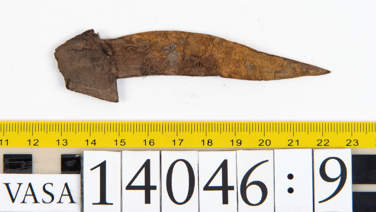 Tjugo ospecificerade läderbitar samt ett flertal mycket små fragment. På två av fragmenten, fyndnummer 14046:1 samt 14046:7, finns svarta hårstrån, ca 5-20 mm långa. Lädret saknar hål efter stygn eller träpligg.