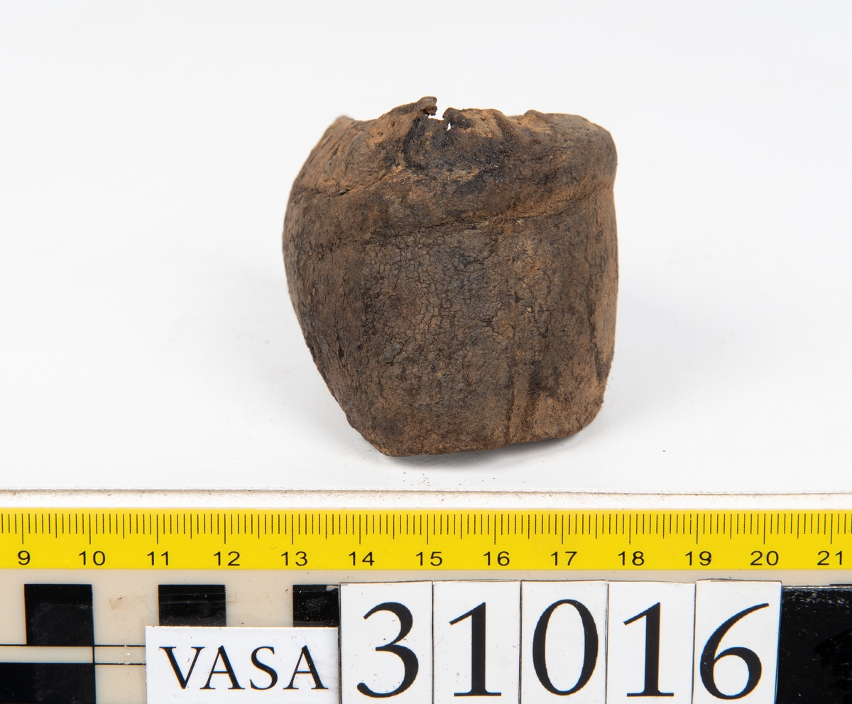 Ovanläder och bakkappa till sko. Längs med ovanlädrets ytterkant löper en enkel rad med stygnshål. Narvytan är välbevarad och har en rutmönstrad struktur. Bakkappans nedre kant är vikt. Kanten har legat invikt och suttit fästad i sulpaketet.