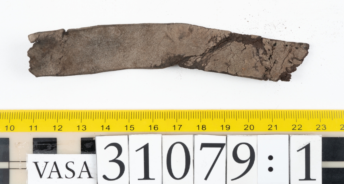 Två delar tillhörande en stövel: en stropp samt en del av en stropp från ett stövelskaft.

Den ena stroppen ligger dubbelvikt. I två av ändarna finns stygnshål efter fastsättningen. Lädret är välbevarat.

Den andra stroppen är fragmentarisk. I ena änden finns stygnshål i forman av en rektangel. Lädret är sprucket och något spaltat.