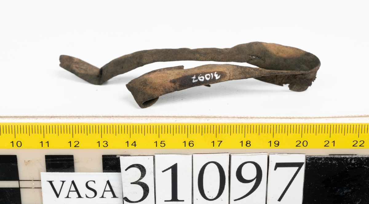 Läderband i tre delar: en längre och två kortare delar. Bandens bredd uppgår till ca 10 mm. Det längre bandet är spaltat. Banden ligger vikta.