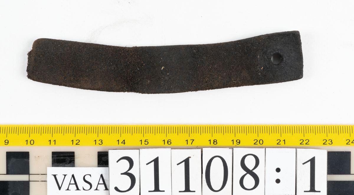 Två delar av en läderrem.
Den längsta delen av remmen är försedd med fem hål. Det femte hålet är placerat vid remmens fragmentariska ände. Den motsvarande änden är kantigt skuren. Lädret är mycket kraftigt och välbevarat.
Den kortare delen av remmen är försedd med en fragmentarisk ände samt en rakt skuren eller avklippt ände. Strax innanför den skurna änden finns ett större hål som är försett med fasade kanter. Narvsidan är så gott som helt bortspaltad, i övrigt är lädret kraftigt och relativt välbevarat.