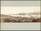 Bilden föreställer en panorama från Nagasaki som är sammansatt av två fotografier. De är tagen från en förhöjd ståndpunkt på kullarna ovan på staden. I förgrunden syns staden låga träbebyggelse och i bakgrunden bukten och hamnen fullt med båtar och skepp. Segelfartyget på vänstra bilden är Vanadis.