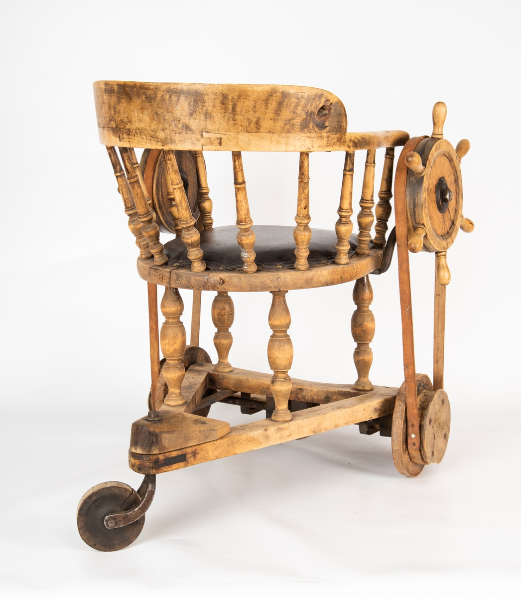 Rullestol i tre, med sete i skinn.