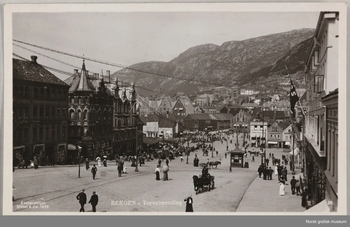 Postkort med motiv nedover Torgallmenningen mot bryggen i Bergen. Det er mange folk i gatene.