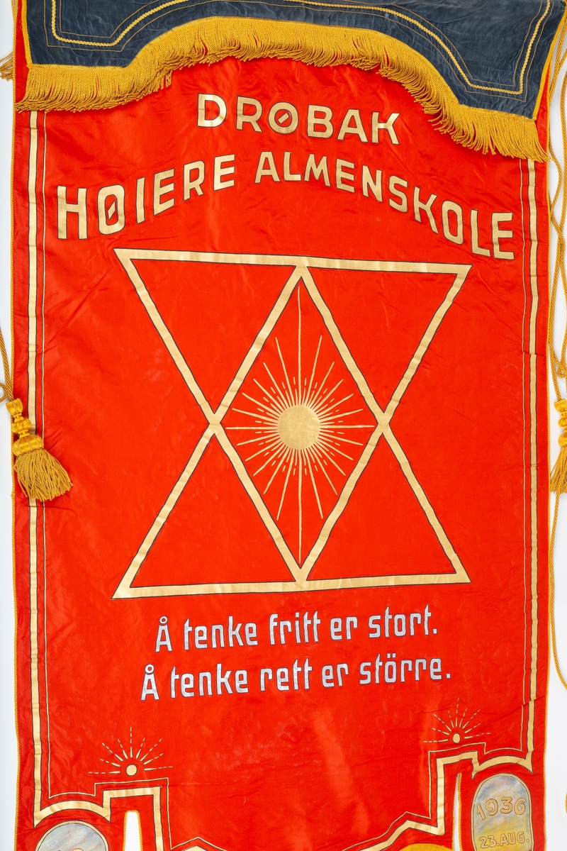 Skolefane for Drøbak borgerskole/Drøbak høiere almenskole. Fanen laget til skolen 50-års jubileum i 1936. Silke eller kunstsilke. 
Ene siden rødt stoff med malt skrift og dekorasjon i sølv og gull: 
"DRØBAK HØIERE ALMENSKOLE   Å TENKE FRITT ER STORT   Å TENKE RETT ER STØRRE"
"1886 23 august. 1936 23. august"

Den andre siden blått stoff med malt dekorasjon i gull: Stjerne med stråler "DRØBAK BORGERSKOLE" 
En mørk blå fløyelskant dekker fanen helt øverst. Denne kan være sekundær. 
Fanen er utstyrt med gullsnorer og dusker. Fanen er festet til en trestang med store metallkuler i endene. Trestangen kan være sekundær da det ser ut til at metallkulene har vært festet annerledes. 
Mye tyder på at fanen har vært hengt opp da det er kroker festet til stangen.

Påskrift: Drøbak Borgerskole 1886.
             Drøbak høiere allmennskole
             Å tenke fritt er stort
             Å tenke rett er større