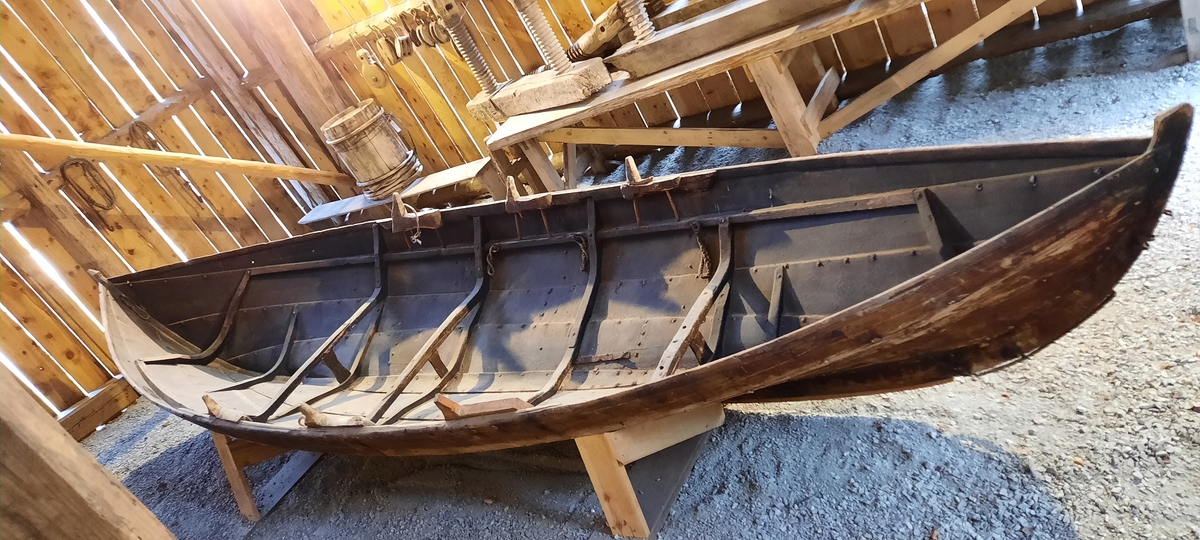 Båt. Nordfjordbåt. Seksæring. For årer og segl (råsegl). Klinkbygd trebåt med 4 omfar. Tjæra innvendig og utvendig, mørk brun farge. På oversida av ripbordet er det ei slitelist som er spikra ned ovanfrå. Firkanta roer.