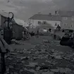 Torget på kvällen efter marknaden i Borgholm. Skräp på marken. Skandinaviska banken och Åbrinks i bakgrunden.