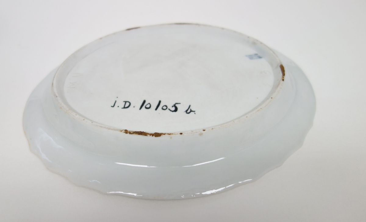 Tekanne og skål. Hører opprinnelig ikke sammen.
DM.10105a = kanne (ukjent produsent)
DM.10105b = underskål (Royal Copenhagen)