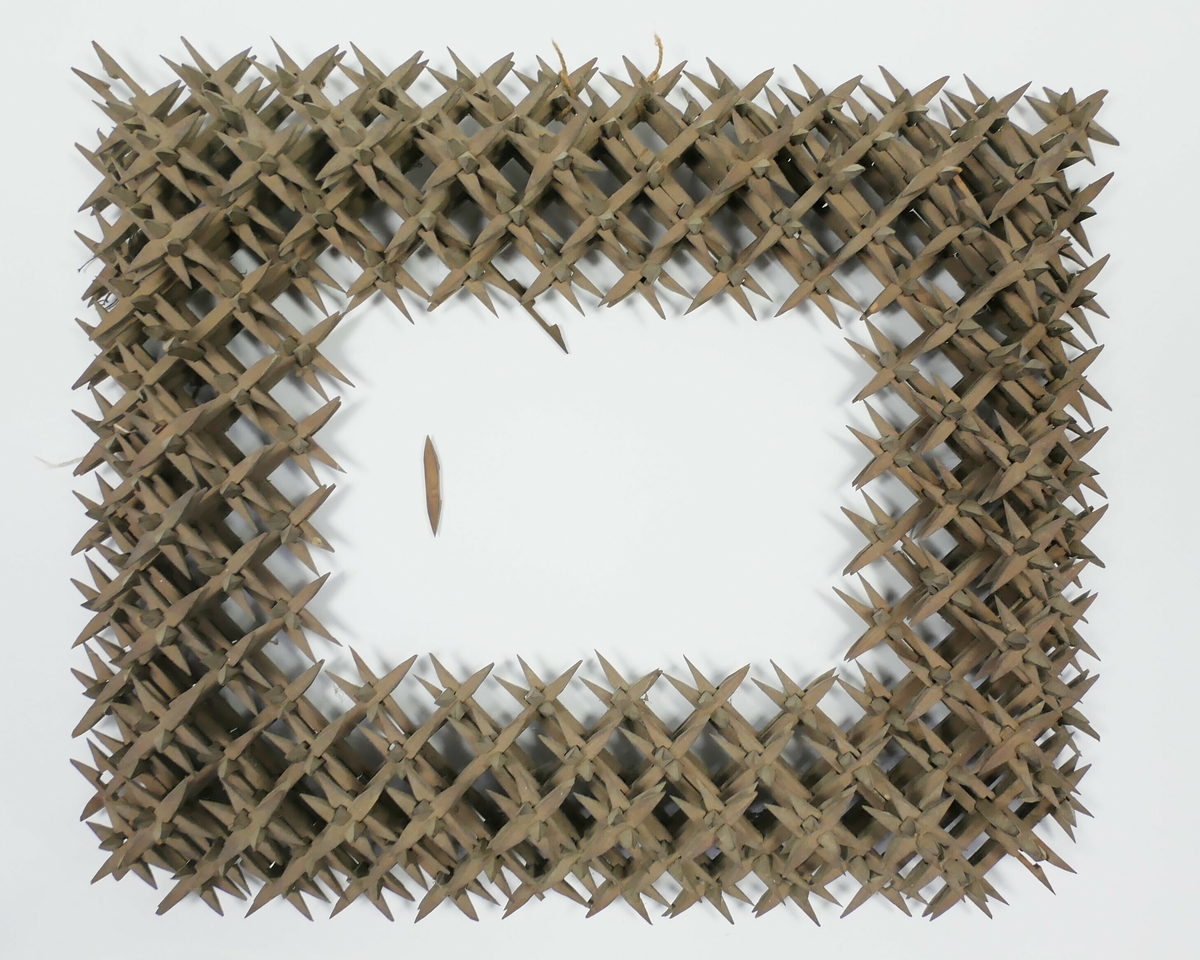 Rektangulær bilderamme laga av skråtobakkspinner som er satt saman. 