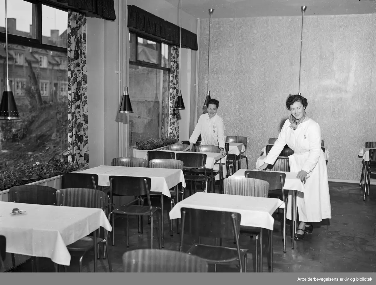 Edel Moe og Valborg Pedersen, ansatte i et nyåpnet konditori (ikke navngitt) på hjørnet av Arendalsgata og Bentsebrugata på Sagene. Juni 1953.