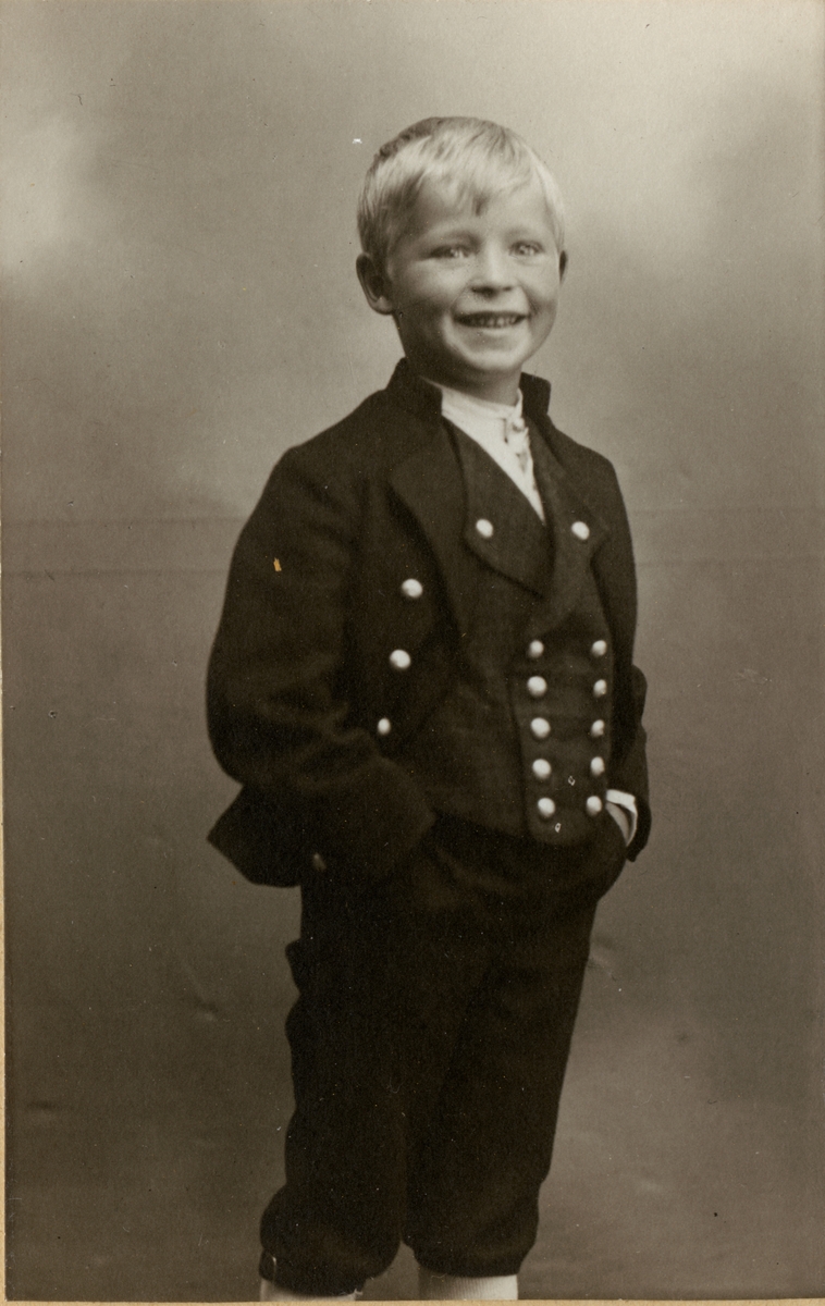 Billedserie med 8 fotografier av Sigrid Undsets sønn Hans Benedict Undset Svarstad som barn, kledd i bunad.