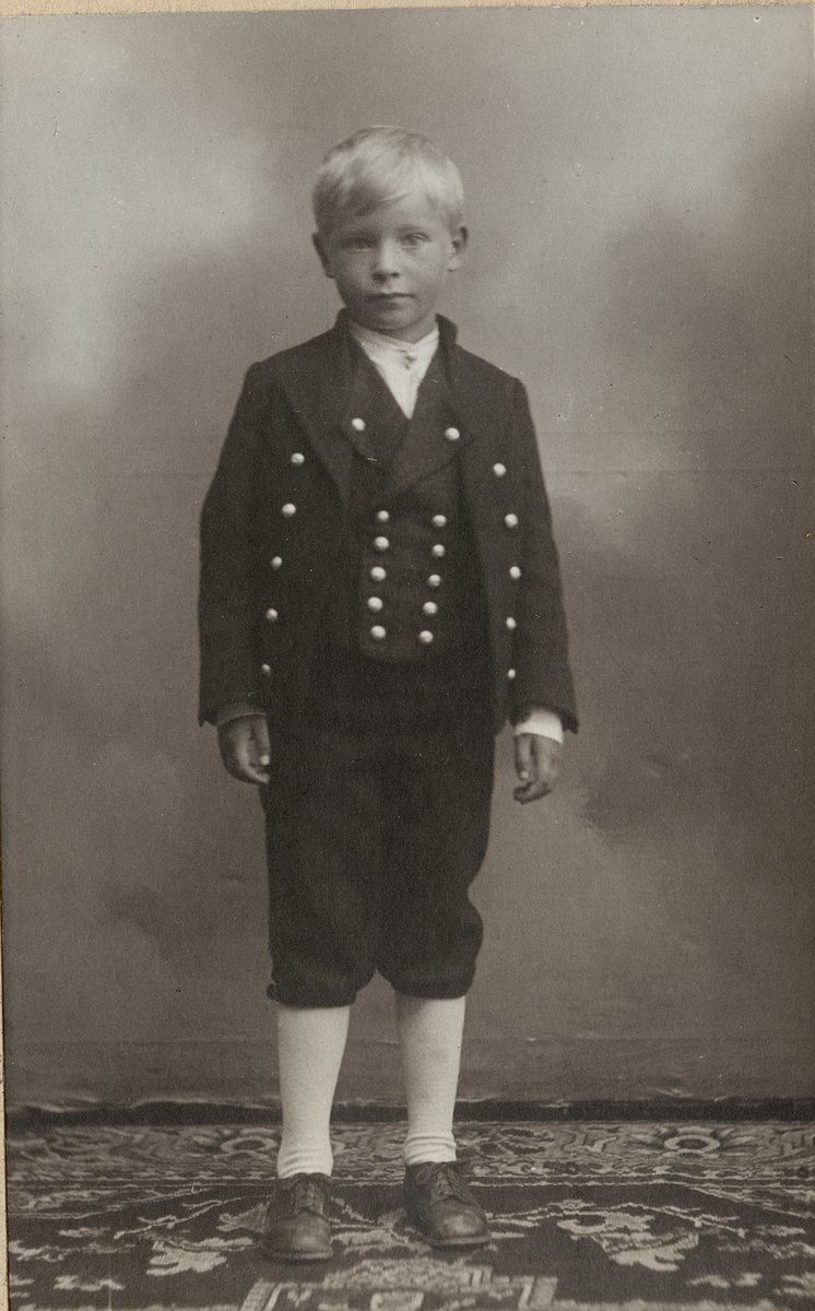 Billedserie med 8 fotografier av Sigrid Undsets sønn Hans Benedict Undset Svarstad som barn, kledd i bunad.