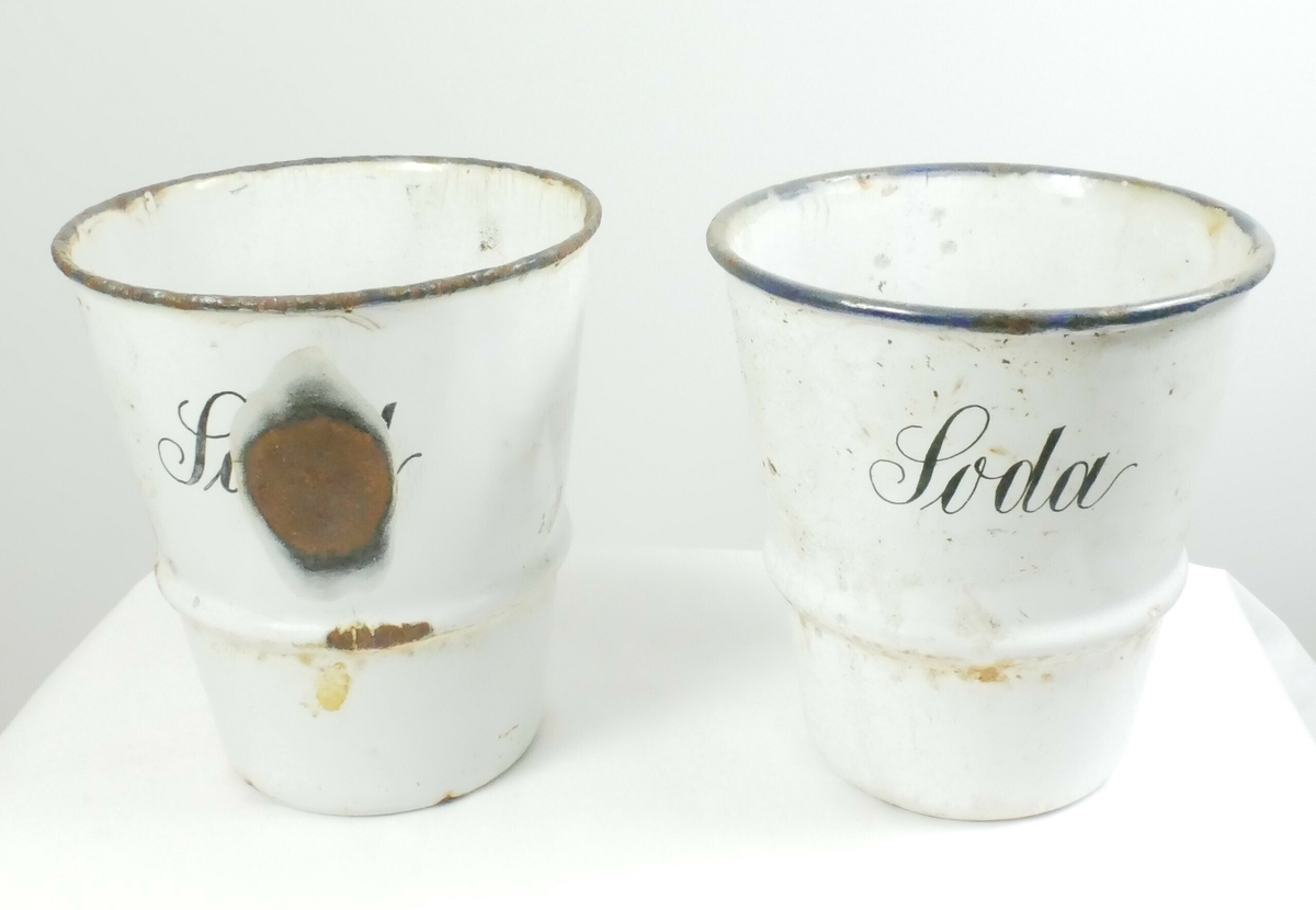 Hylle i metall. Bølgete kant med to hull i hvert hjørne til å feste på vegg. Nederst er det tre hull til feste av beholdere. 3 runde beholdere med blå kant tilhører hyllen. 