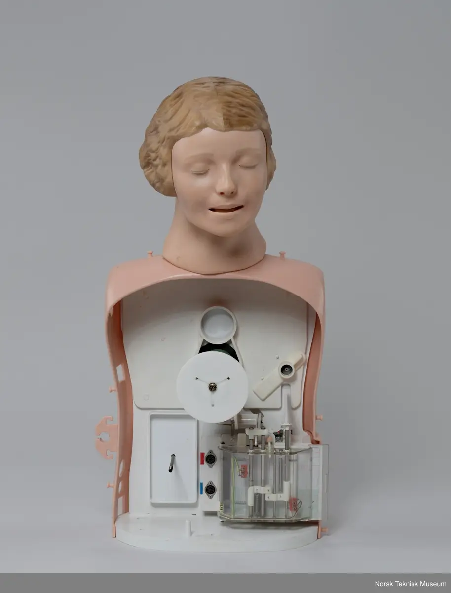 Koffert, med "Recording Resusci Anne", ekstra Resusci-Anne hode, to brystdeksler, fire armer, løsnede ben.