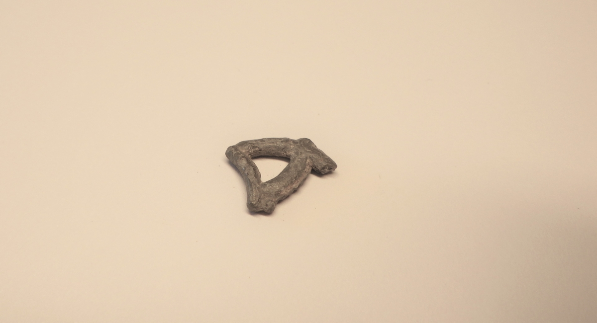 MALV: ST. M. 15  B. PÅ BÅNDET 2, 2 MM, FRAGMENT AV EN UTSTANSET DEKOR. 