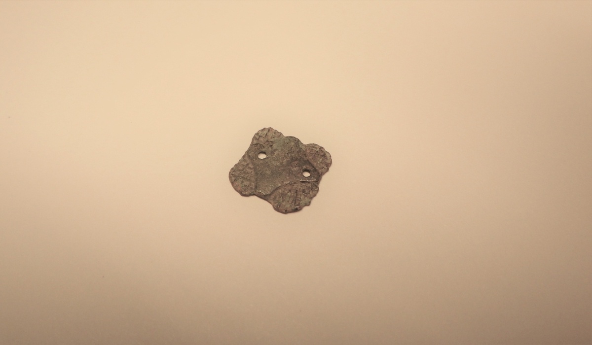 MALV: 12*11 MM, TILNÆRMET KVADRATISK MED SVAKT BUEDE SIDER OG RUNDEHJØRNER SOM HAR RUTEDEKOR. MIDTFELTET ER UTEN DEKOR OG HAR TO HULLERTIL FESTE. 