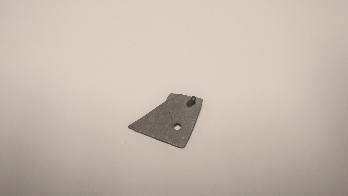 MALV: L. 6, 5  B. 6 MM, BÅNDFORMET. TO HULL MED ISITTENDE STIFT I DET ENE. AVKUTTET I ENE ENDEN. UTEN DEKOR. 