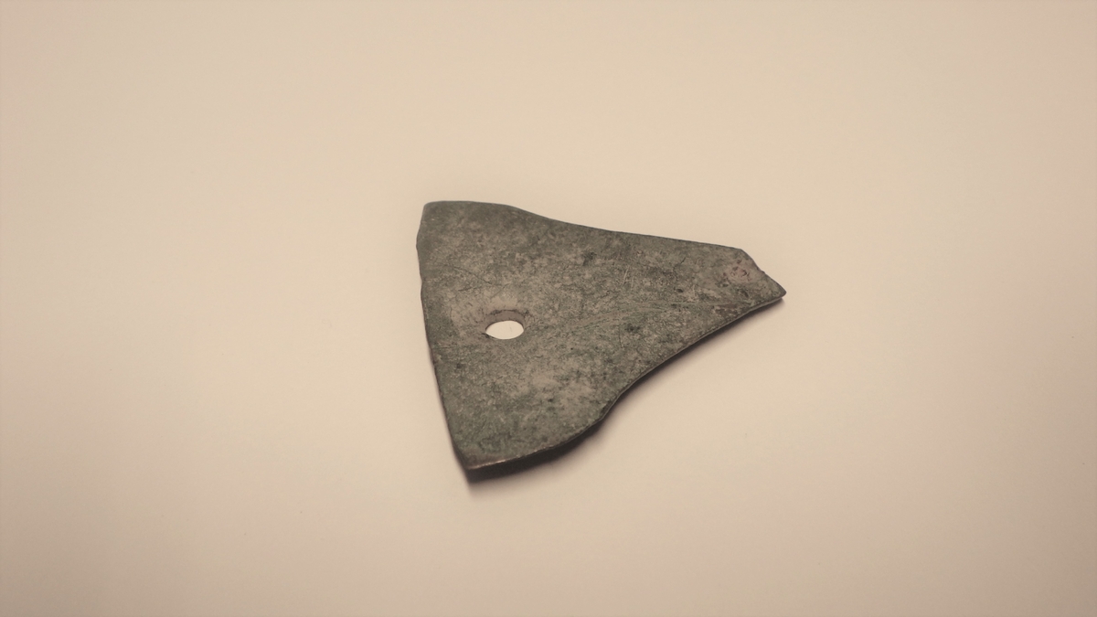 MALV: 40*38 MM, TRIANGULÆR MED SVAKT KONKAVE SIDER. 2 HULL, HVORAVDET ENE HAR ISITTENDE NAGLE. 